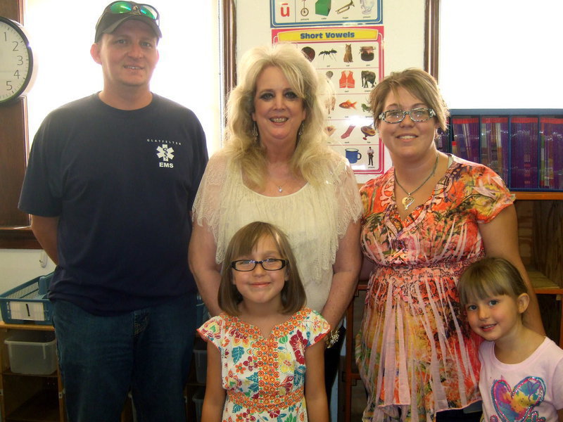 Image: Greg Sutton, Mrs. Nelson (teacher), Harley Sutton, Jessica Sutton, and Ireland Sutton are all ready for school.