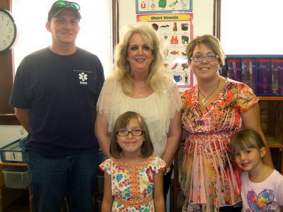 Image: Greg Sutton, Mrs. Nelson (teacher), Harley Sutton, Jessica Sutton, and Ireland Sutton are all ready for school.