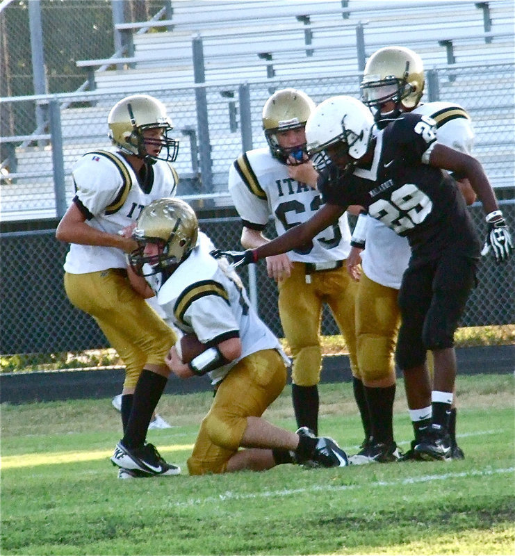 Image: Brandon Connor(4) helps up teammate Kyle Fortenberry(66) after Fortenberry covers an onside kick attempt by Malakoff.