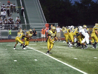 Image: Jalarnce Lewis(21) takes the handoff from Eric Carson(12) and then looks for a running lane.