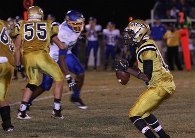 Image: Eric Carson(12) gets protection behind Zackery Boykin(55), Kevin Roldan(60) and the rest of his offensive line.