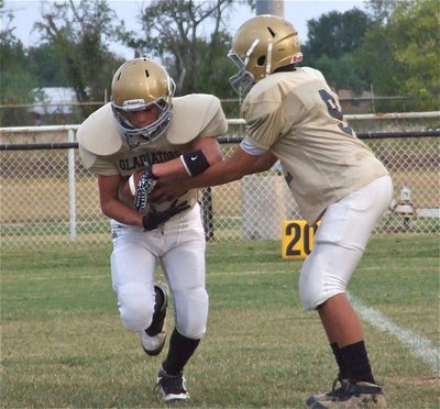 Image: 8th grade quarterback Devonteh Williams(9) hands off to teammate Joe Celis(24).