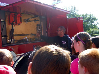 Image: Italy Volunteer Fireman Brad Chambers showing the students the tools the firemen use.