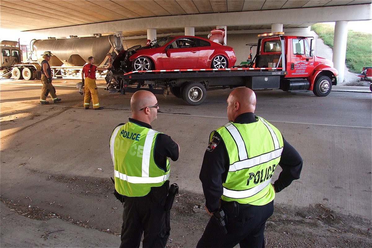 Image: Officer Shawn Martin an Chief Diron Hill of the Italy Police Department monitor the clean up.