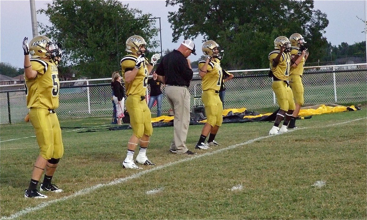 Image: Head coach Hank Hollywood spins the wheels as Zackery Boykin(55), Chase Hamilton(2), Reid Jacinto(11), Ryheem Walker(10) and Cole Hopkins(9) lead their teammates thru pre-game warmups.