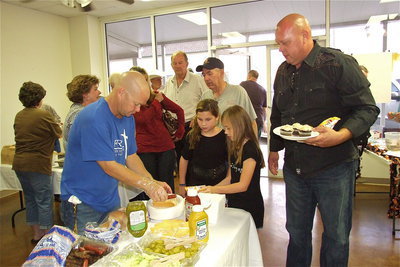 Image: Italy Police Chief Diron Hill gets served a hot dog from Italy Firefighter Michael Chambers.