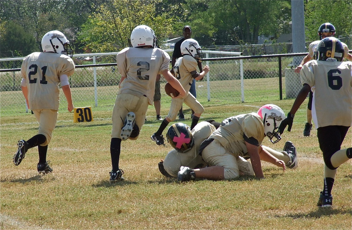 Image: IYAA A-Team lineman Alex Garcia(50) takes down a Jaguar defender allowing quarterback Ethan Itson(2) to turn the corner for a long gain.