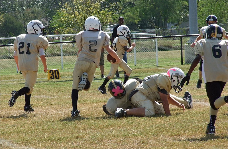 Image: IYAA A-Team lineman Alex Garcia(50) takes down a Jaguar defender allowing quarterback Ethan Itson(2) to turn the corner for a long gain.