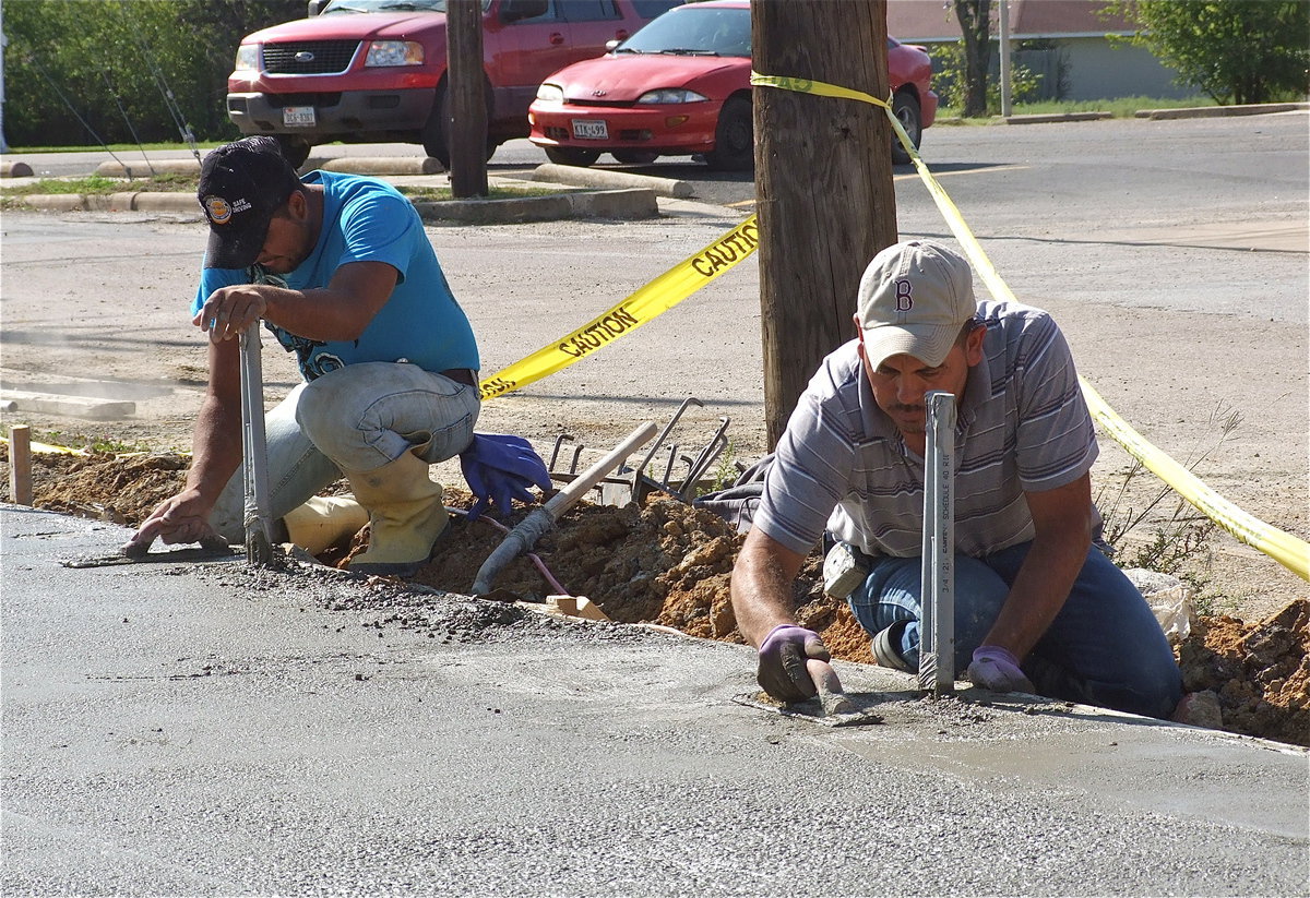 Image: The concrete is poured and workers begin smoothing the surface.