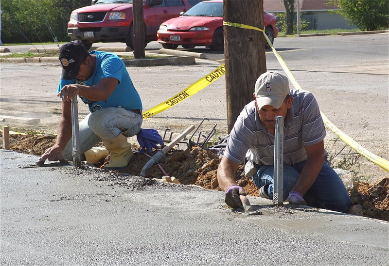 Image: The concrete is poured and workers begin smoothing the surface.