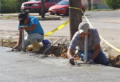 Image: The concrete is poured and workers begin smoothing the surface.