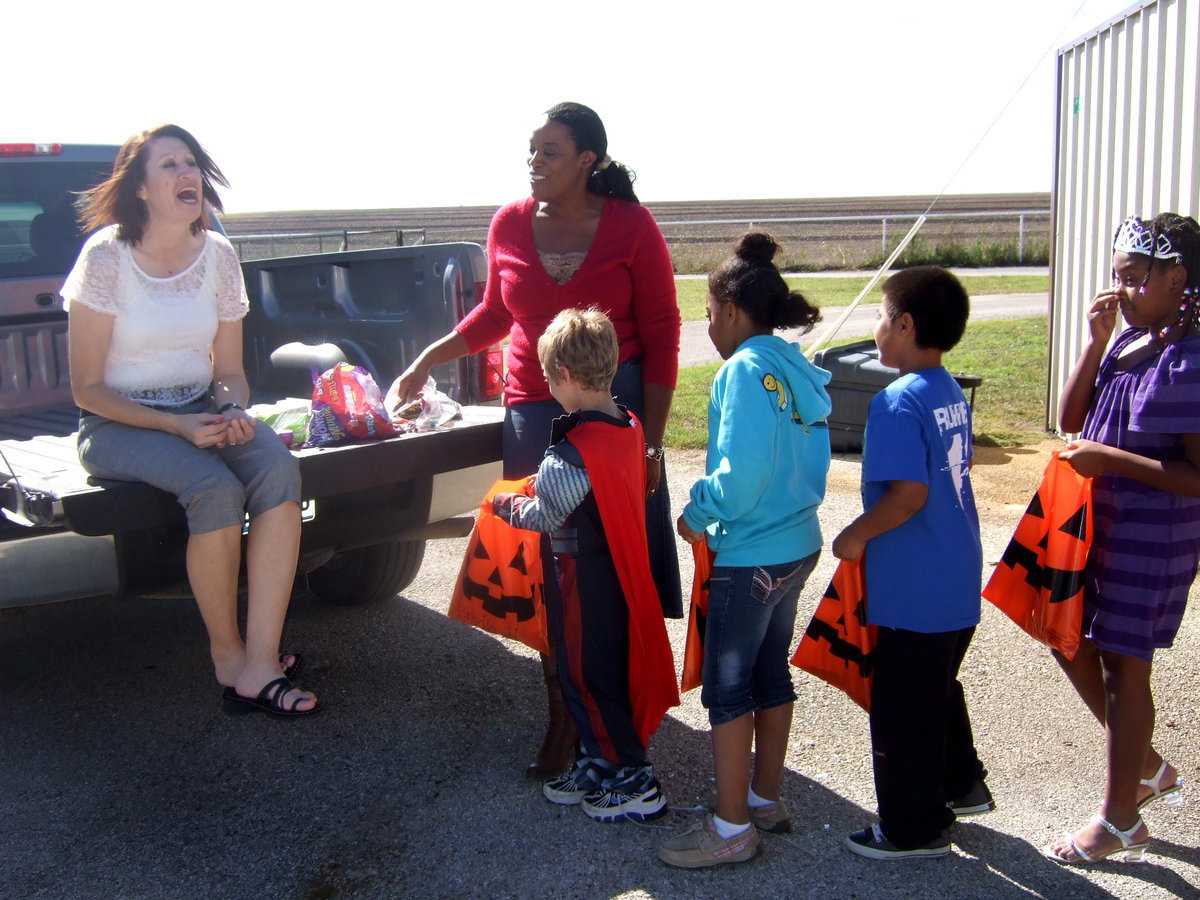 Image: Teachers having fun handing out treats.