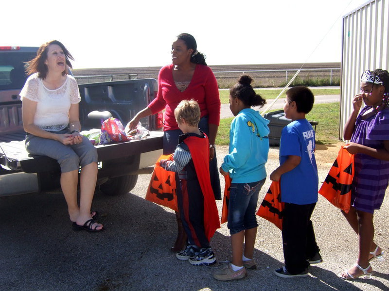 Image: Teachers having fun handing out treats.