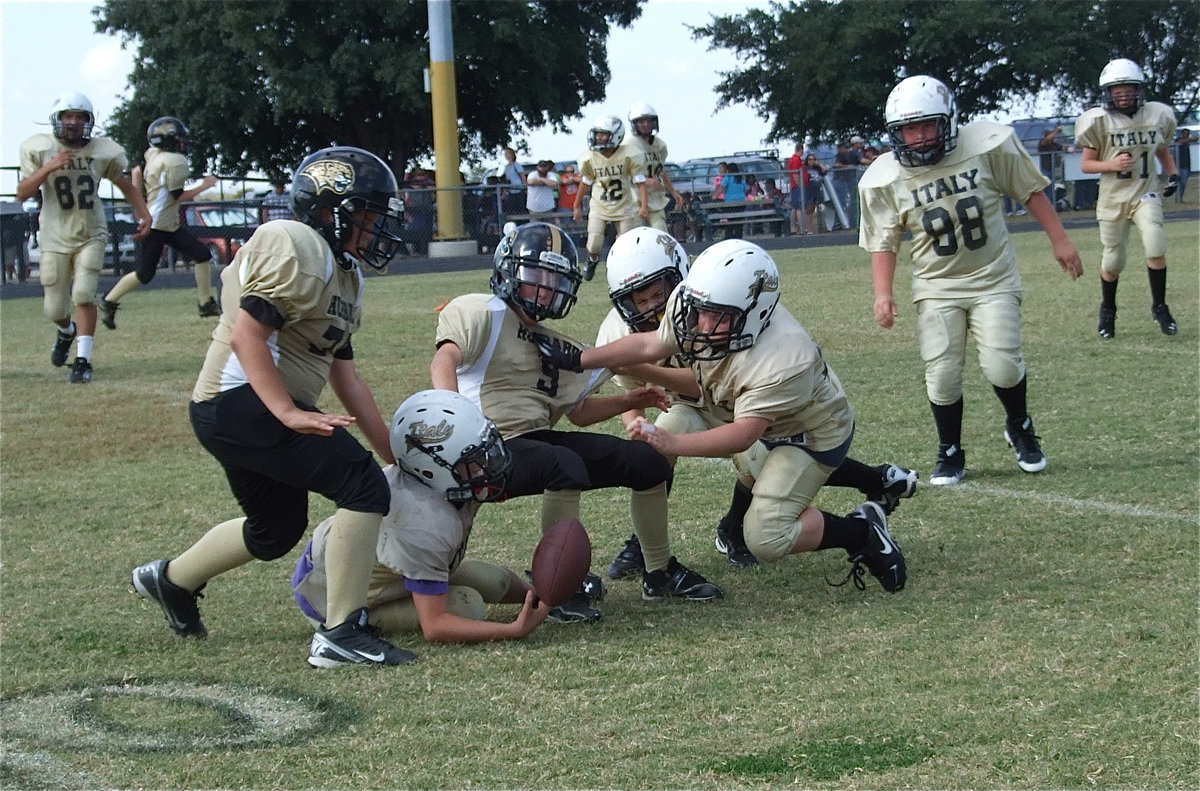 Image: Italy’s Aedan Brewer(22) pushes a Jaguar away allowing teammate Ryder Itson(2) to recover Italy’s kickoff in the fourth-quarter.