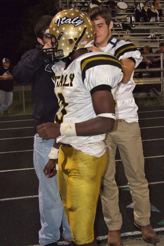 Image: Tyler Anderson and Hayden Woods(8) assist Gladiator quarterback Marvin Cox(3) with a helmet malfunction.