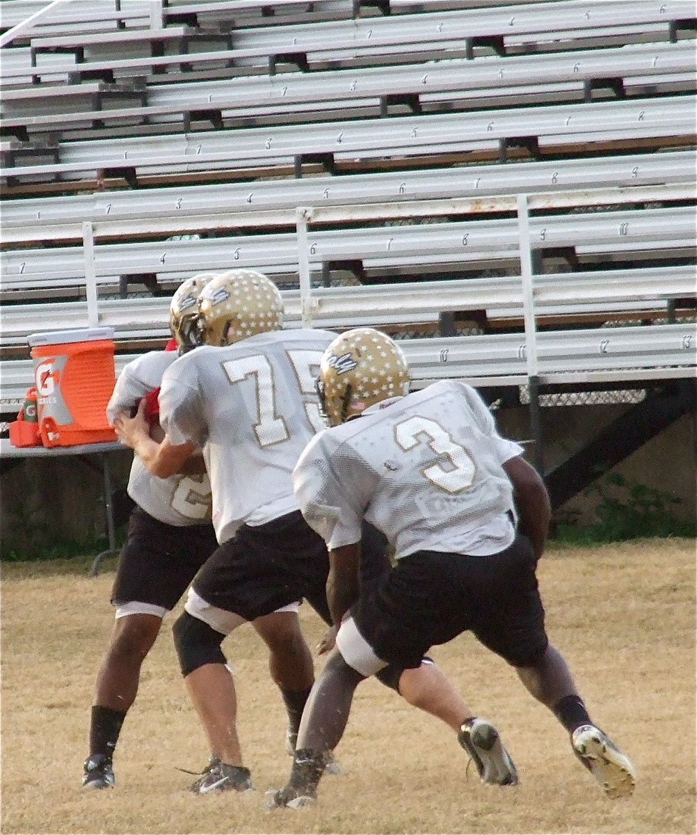 Image: Cody Medrano(75) leads the way for Marvin Cox(3) with Jalarnce Lewis(21) giving the offense some pressure.