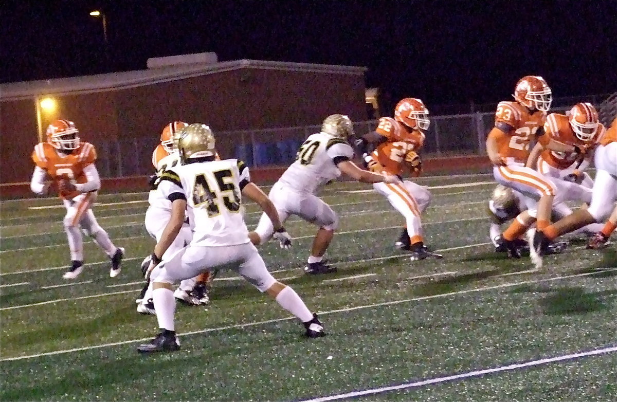 Image: Hunter Merimon(45) keeps an eye on the quarterback as fellow Gladiator and defensive end Zain Byers(50) zeroes in on Honey Grove’s Demontrae Finney(22).