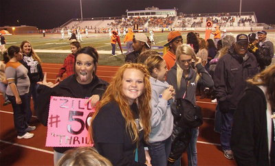 Image: Seniors Breyanna Beets and Katie Byers return from helping to form a 50-yard long spirit line to welcome the Gladiators onto the field.