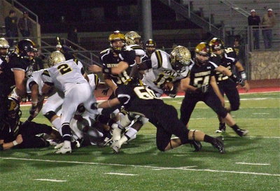 Image: Italy’s Zackery Boykin(55) and Chase Hamilton(2) create a gap for Ryheem Walker(10) who fights for as many yards as he can get.