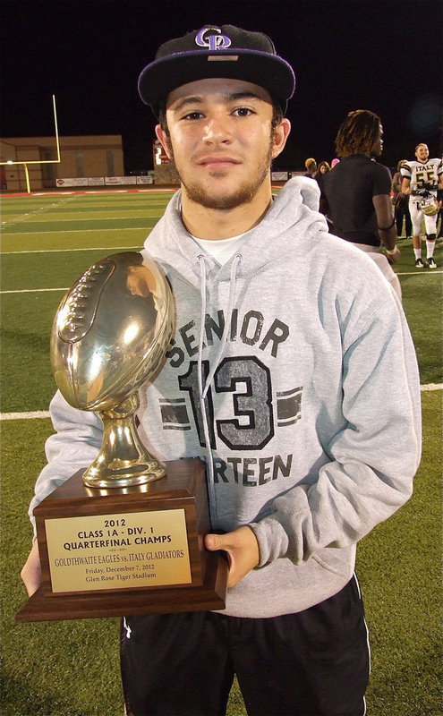 Image: Senior Gladiator Caden Jacinto(6) stands with Italy’s quarterfinal championship trophy after the playoff game in Glen Rose.