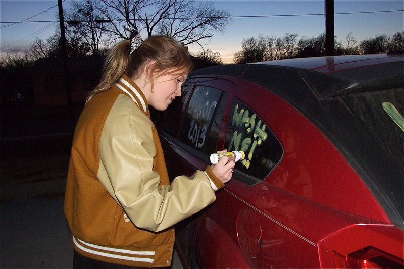 Image: Italy High School cheerleader Taylor Turner helps decorate vehicles to inspire the Gladiators against Stamford, and to encourage car cleanliness, before Italy’s Thursday night pep rally inside the old George E. Scott Coliseum gymnasium.
