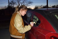 Image: Italy High School cheerleader Taylor Turner helps decorate vehicles to inspire the Gladiators against Stamford, and to encourage car cleanliness, before Italy’s Thursday night pep rally inside the old George E. Scott Coliseum gymnasium.
