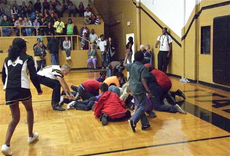Image: Gladiator Brandon Connor(77) and cheerleader K’Breona Davis decide they want some of the candy from the piñata.