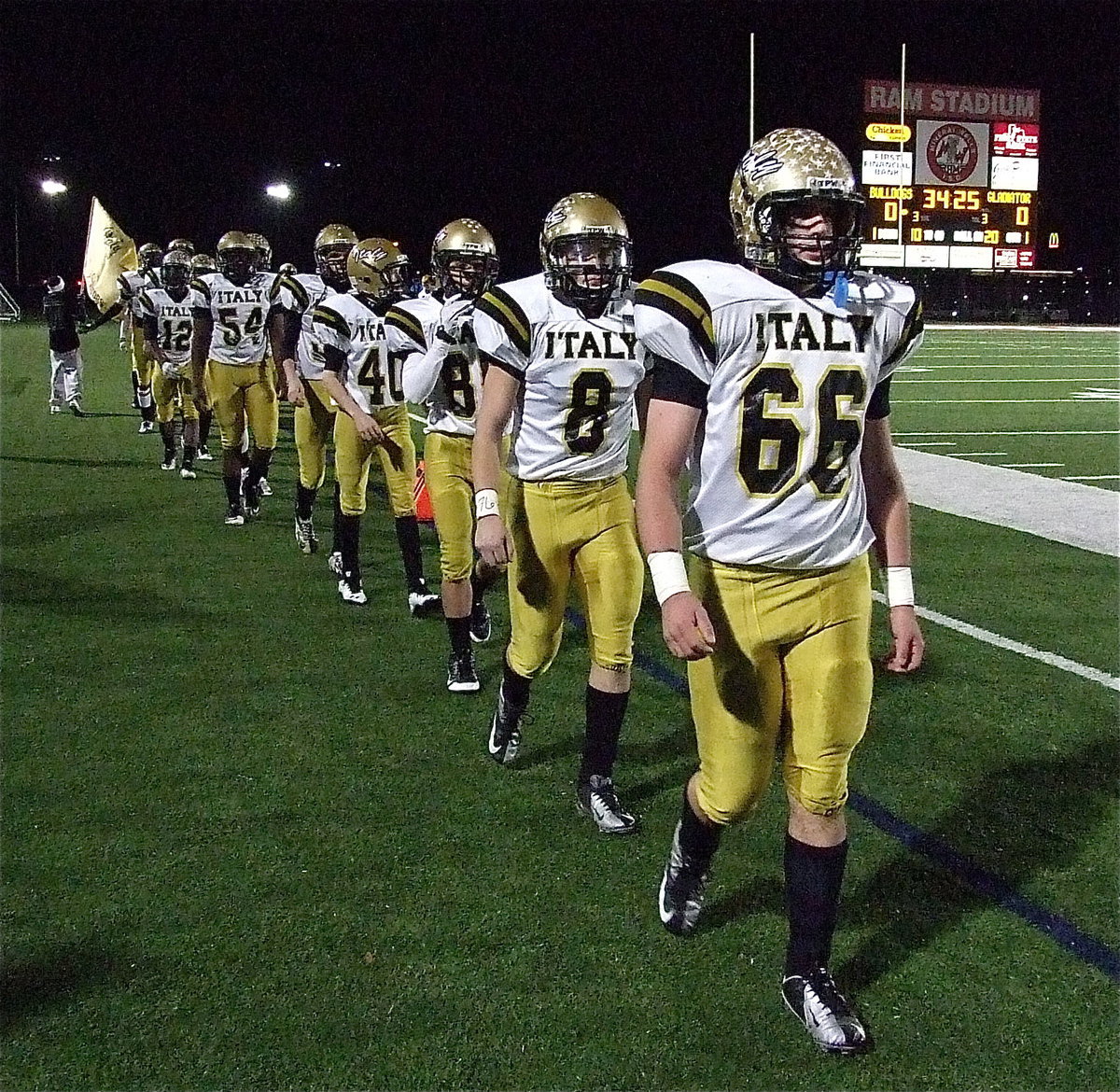 Image: Gladiators Kyle Fortenberry(66) and Hayden Woods(8) and their teammates match into battle.