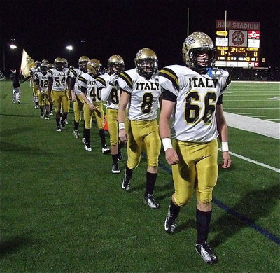 Image: Gladiators Kyle Fortenberry(66) and Hayden Woods(8) and their teammates match into battle.