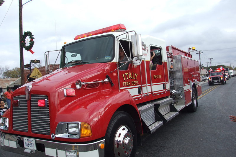Image: Italy firefighter Brad Chambers makes some noise to help clear the way for Mr. and Mrs. Claus.