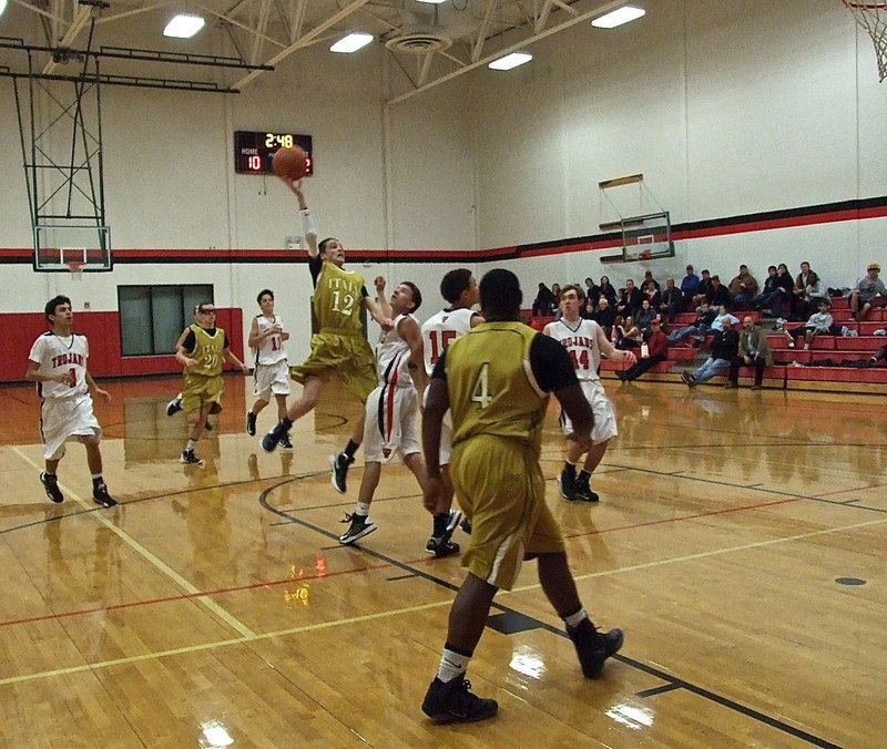 Image: Ty Windham(12) tries to dunk it from the free-throw line as teammate Billy Moore(4) moves in for the rebound, just in case, during a JV matchup between Italy and West.