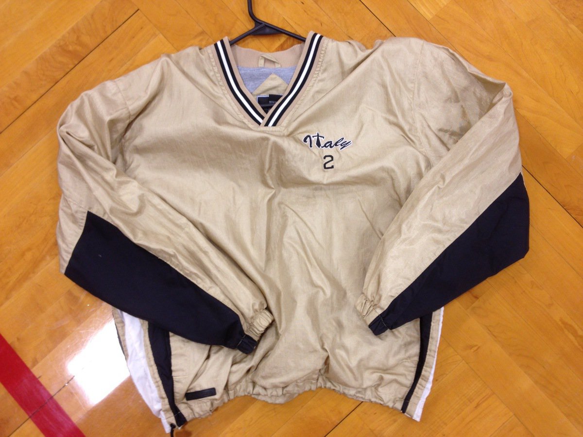 Image: A gold, white and black coverup/windbreaker with an Italy logo on the chest.