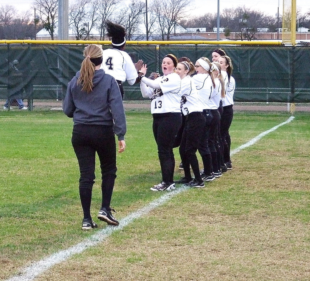 Image: K’Breona Davis is really excited for the 2013 season as teammates lineup to slap hands with Davis.