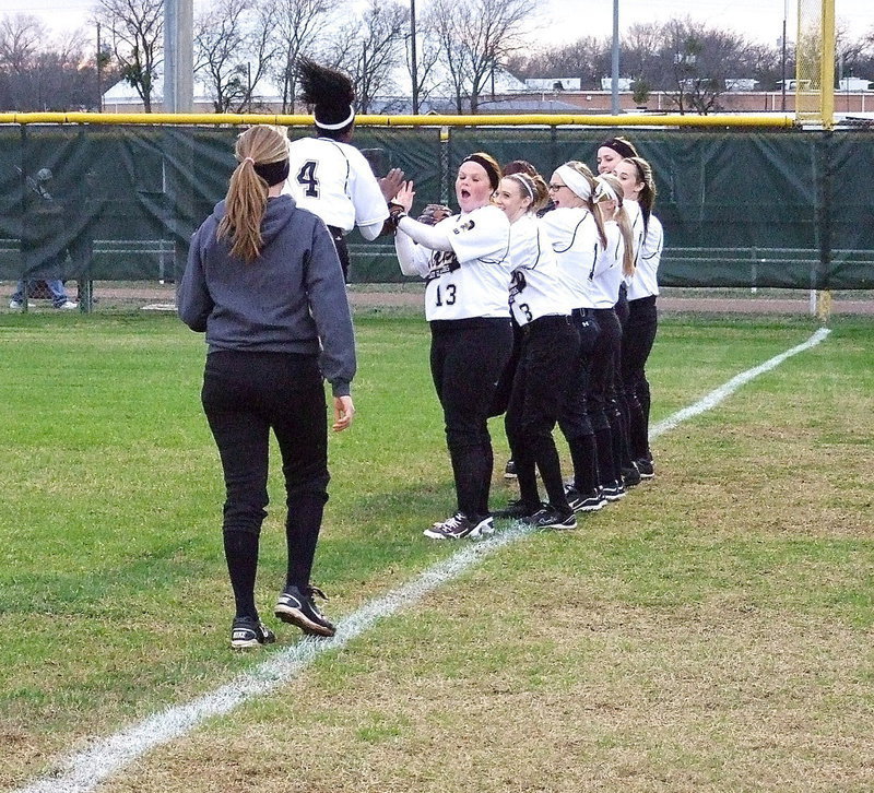 Image: K’Breona Davis is really excited for the 2013 season as teammates lineup to slap hands with Davis.