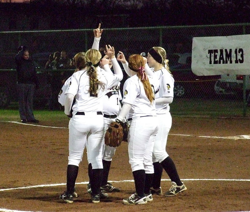 Image: Italy’s infield meets in the middle of the diamond for a group moment.