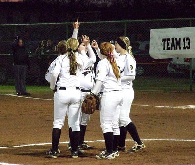Image: Italy’s infield meets in the middle of the diamond for a group moment.