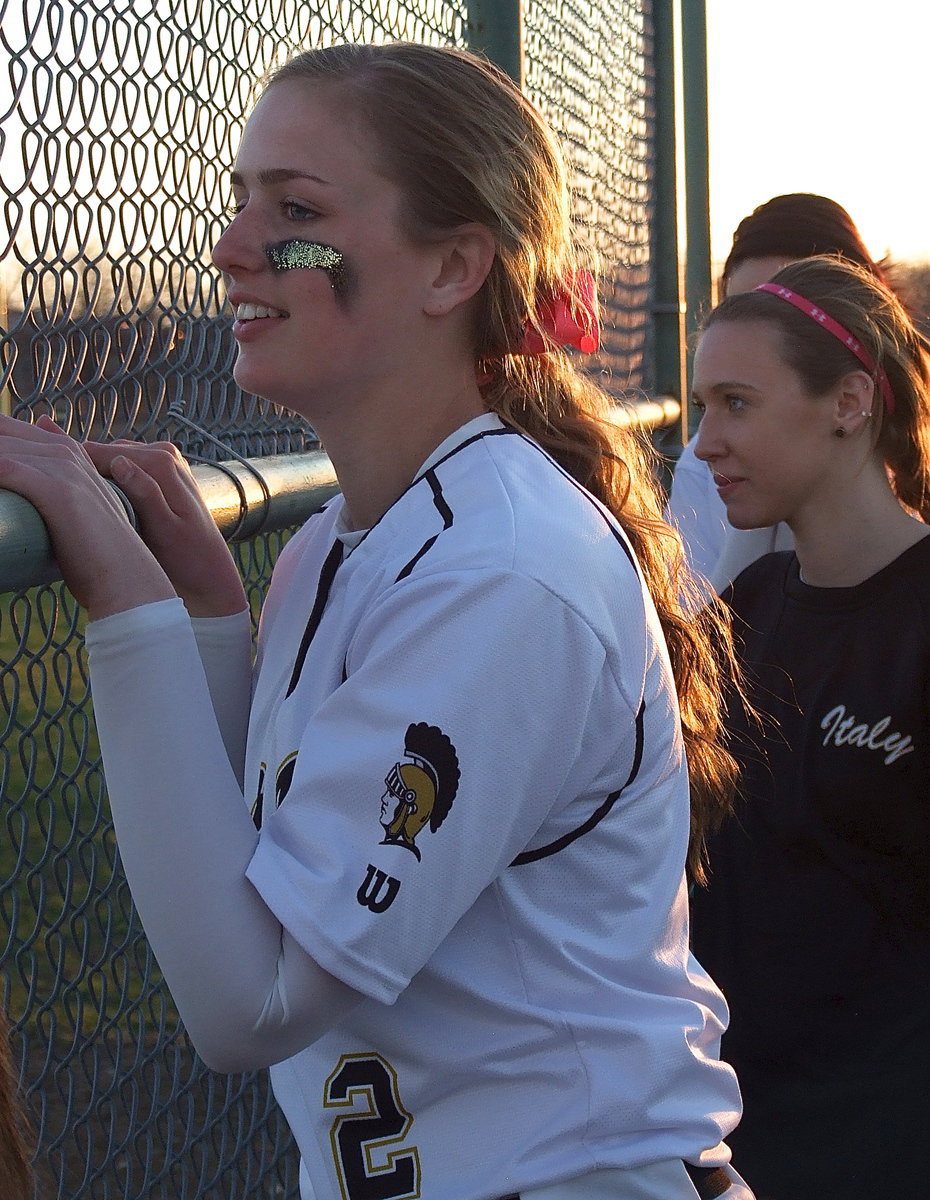Image: Madison Washington(2) and Brooke Miller cheer on Italy’s batters from the dugout.