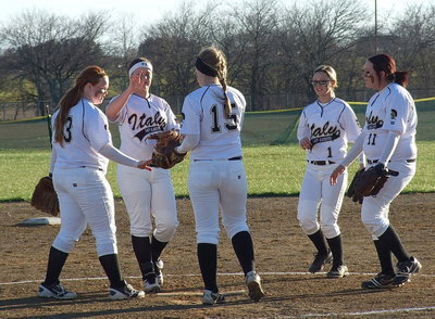 Image: Italy’s Infielders celebrate a strikeout by Jaclynn Lewis(15).