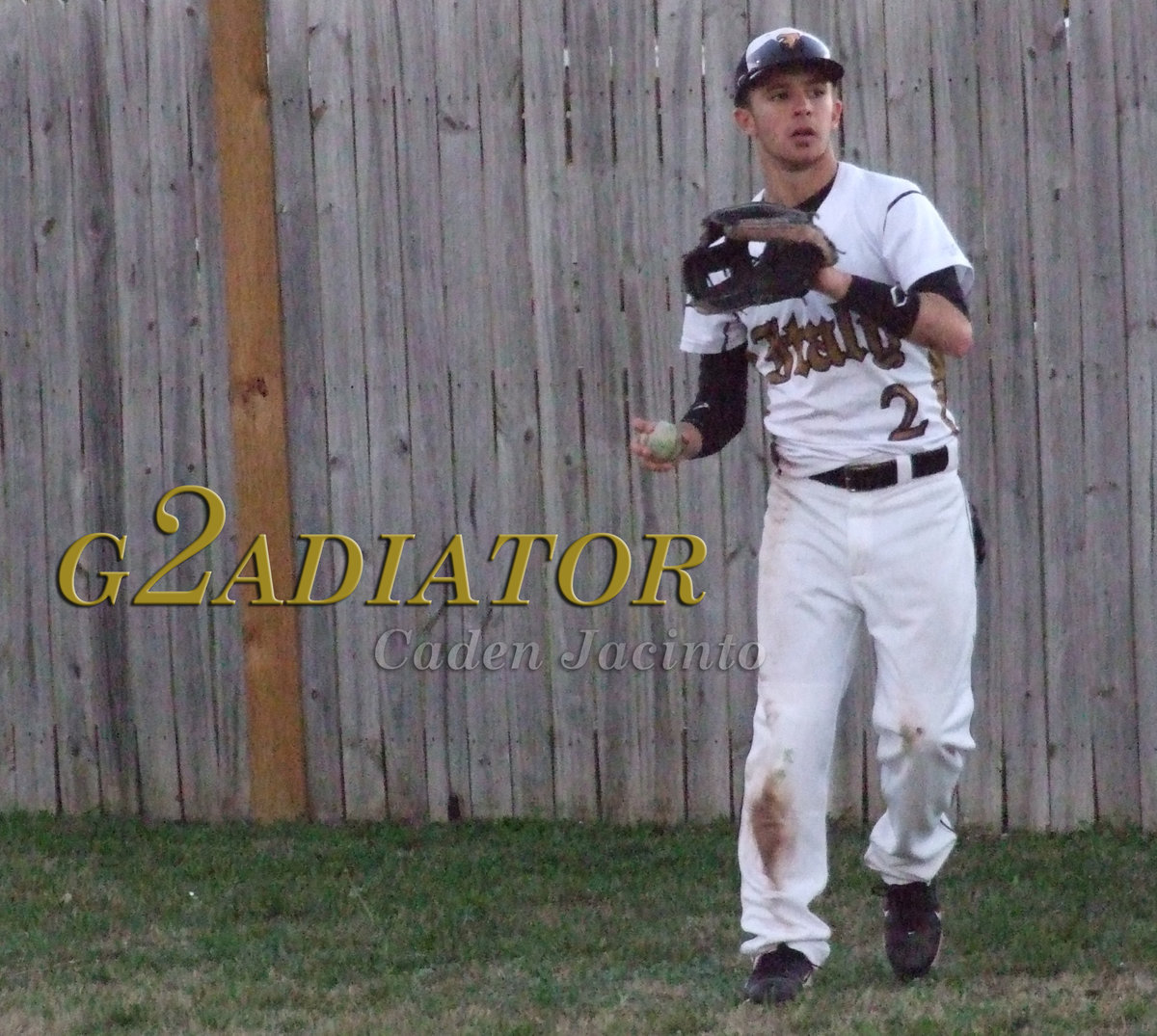 Image: 2 good: senior Gladiator Caden Jacinto(2) warms up in the bullpen….or rather next to the wooden fence behind the Italy home dugout.