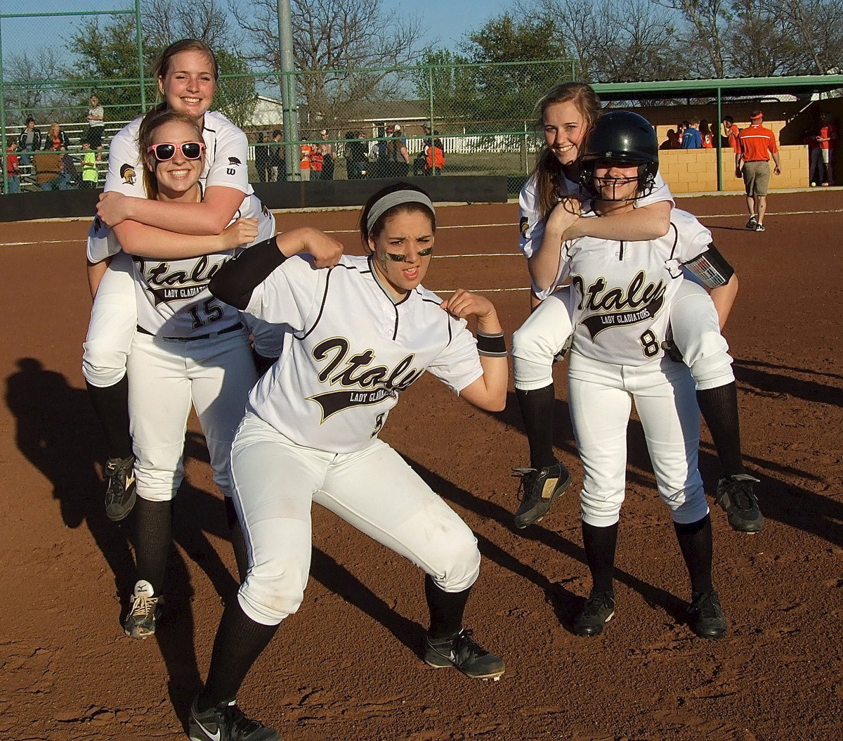 Image: Madison Washington(2) hops a ride with teammate Jaclynn Lewis(15) as does Kelsey Nelson(14) who is carried off the field by Morgan Cockerham(8) while Alyssa Richards(9) blasts the guns in a bit of a victory celebration.