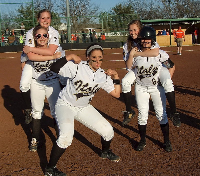 Image: Madison Washington(2) hops a ride with teammate Jaclynn Lewis(15) as does Kelsey Nelson(14) who is carried off the field by Morgan Cockerham(8) while Alyssa Richards(9) blasts the guns in a bit of a victory celebration.