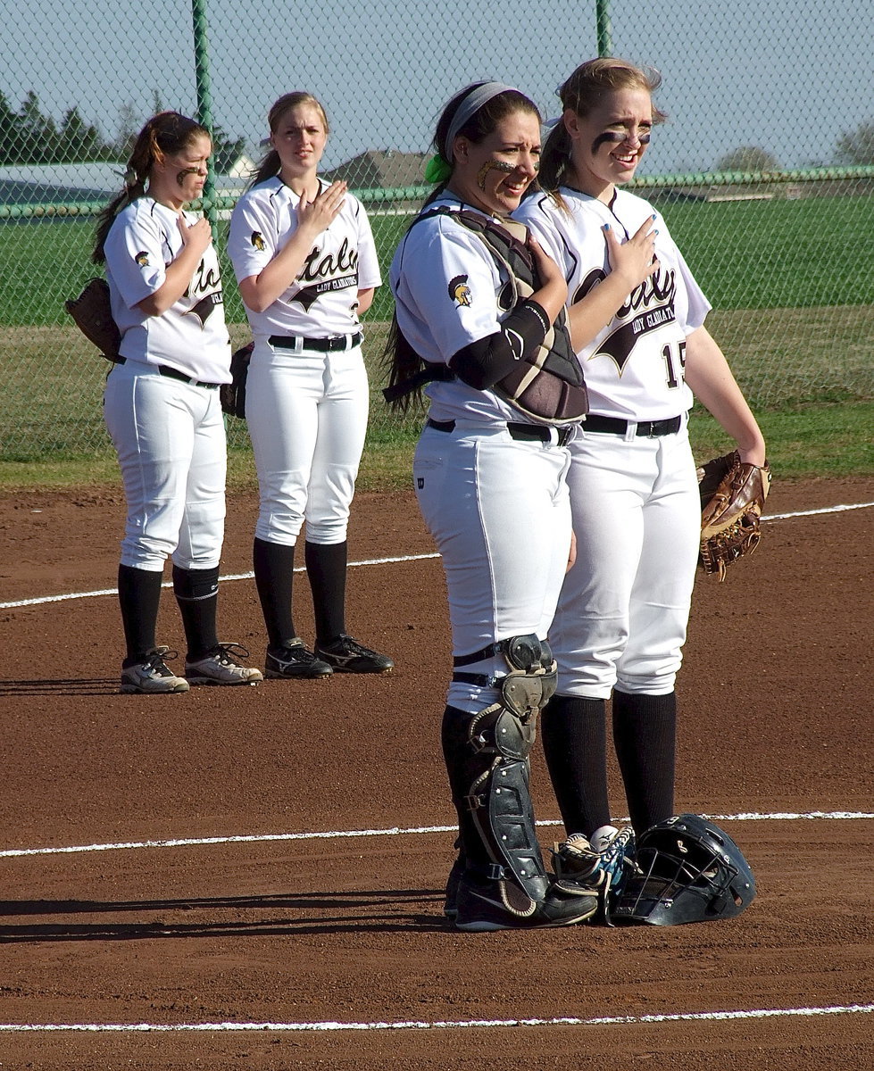 Image: Paige Westbrook(10), Madison Washington(2), Alyssa Richards(9) and Jaclynn Lewis(15) show respect to the nation’s flag during the pre-game ceremony.