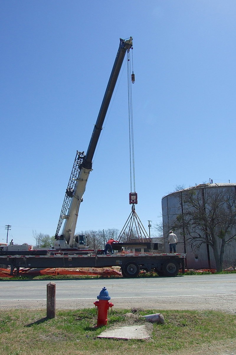 Image: Workers use a crane to help construct the new concrete water tank just down from a previously constructed steel water tank near downtown Italy. The new concrete tank will keep the water cooler than the metal tank and requires less internal maintenance to blast and clean every couple of years.