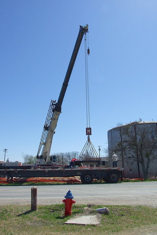 Image: Workers use a crane to help construct the new concrete water tank just down from a previously constructed steel water tank near downtown Italy. The new concrete tank will keep the water cooler than the metal tank and requires less internal maintenance to blast and clean every couple of years.
