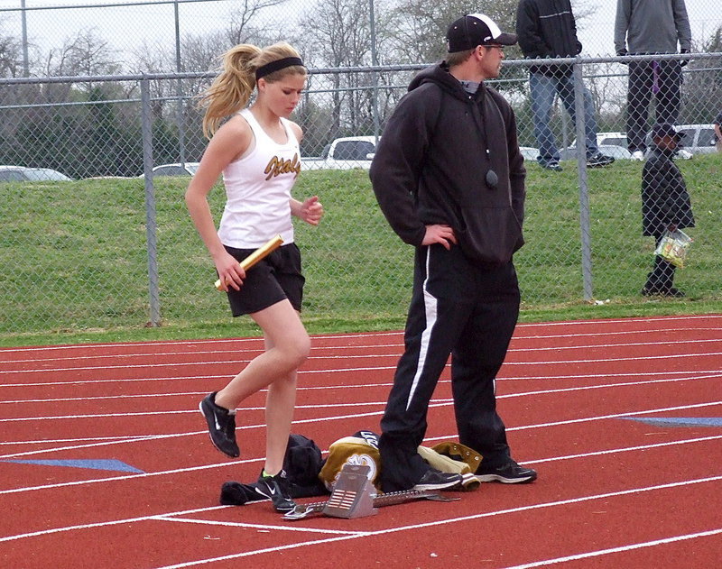 Image: Coach Nate Skelton is ready to hold the block for Halee Turner who stays warm in the afternoon chill.