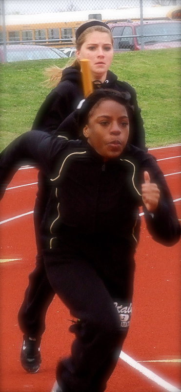 Image: Halee Turner and Kendra Copeland work on baton handoffs.