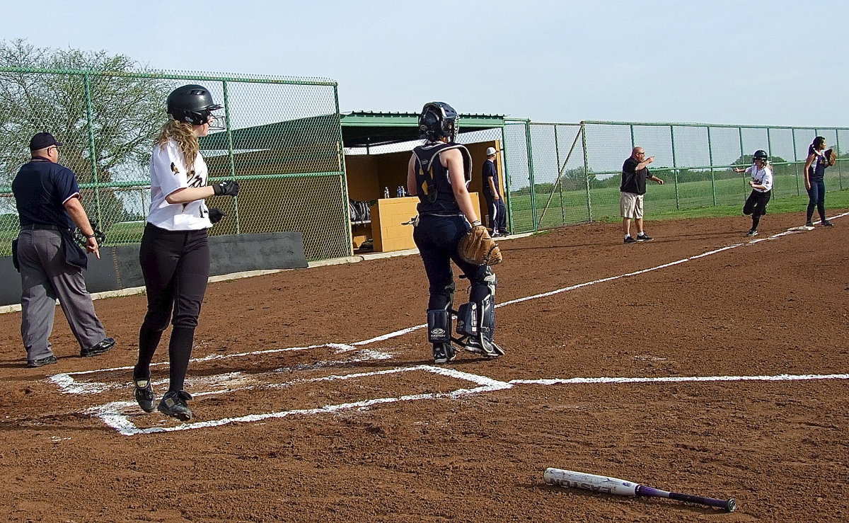 Image: Kelsey Nelson(14) crosses home plate as Britney Chambers(4) hustles around third base to the urging of head coach Wayne Rowe.