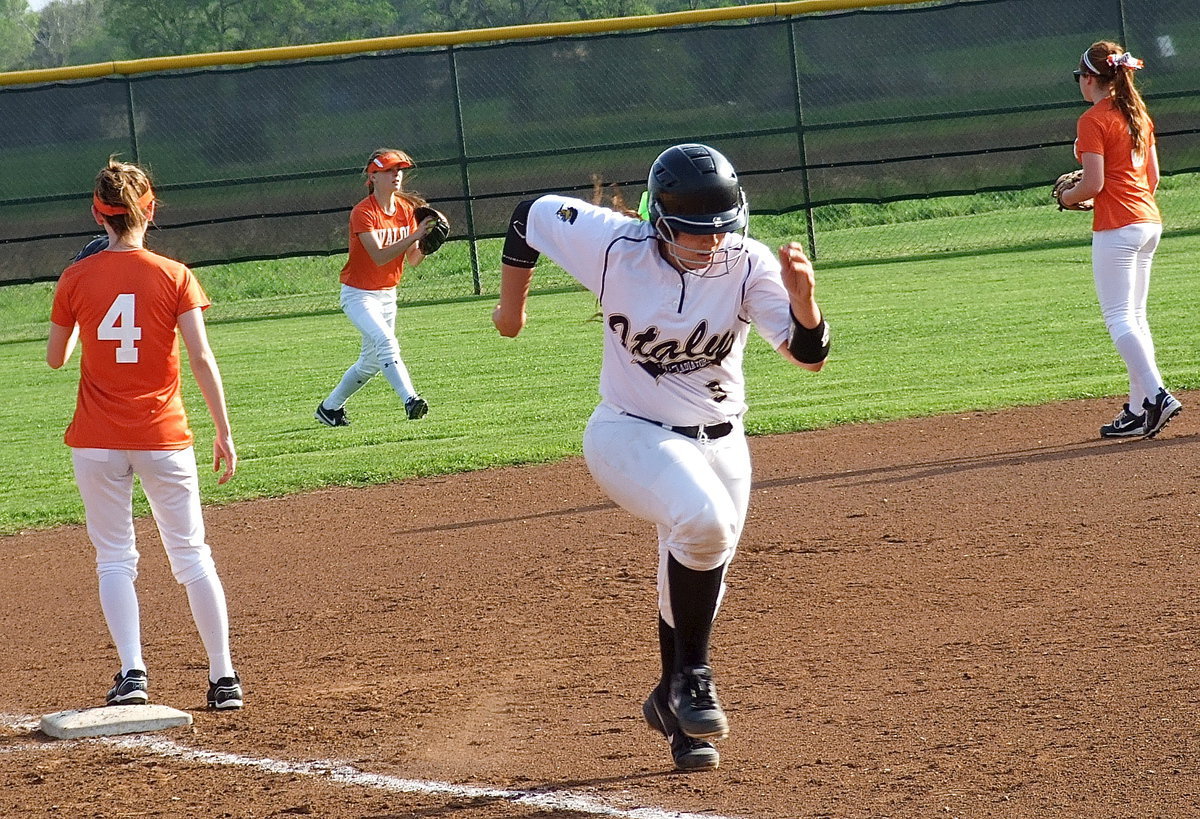 Image: Alyssa Richards(9) charges home after a fly ball drops into left field.
