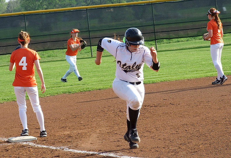 Image: Alyssa Richards(9) charges home after a fly ball drops into left field.