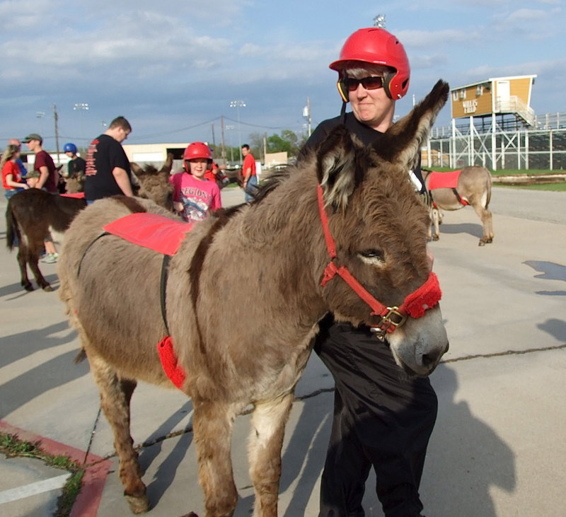 Image: DeeDee Hamilton, a member of the Arse-Kickers consisting of band members and supporting parents, poses with her teammate before entering the Italy Coliseum.